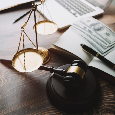 a laptop, money, and a judge scale on a desk a laptop, money, and a judge scale on a desk